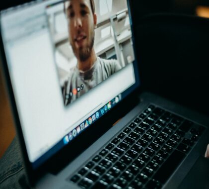 Close-up of a person engaged in a video call on a laptop indoors, showcasing modern technology.